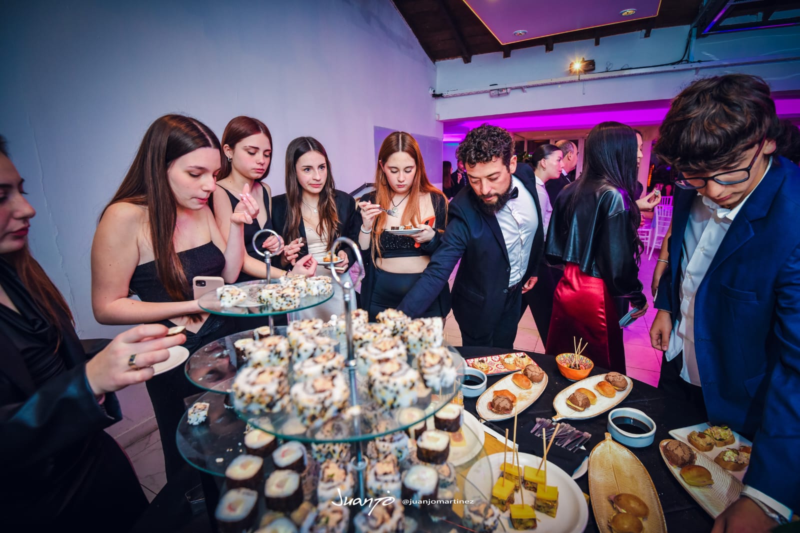 Isla de finger food con invitados sirviéndose